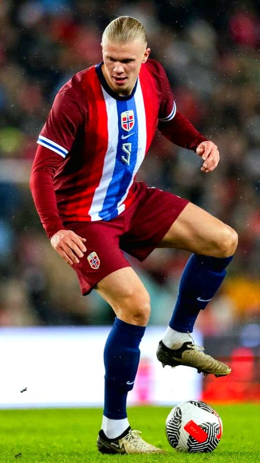A soccer player in a Norway jersey controls a ball on the field during a match, with a blurred crowd in the background—perfect action to experience live with Brasil IPTV.